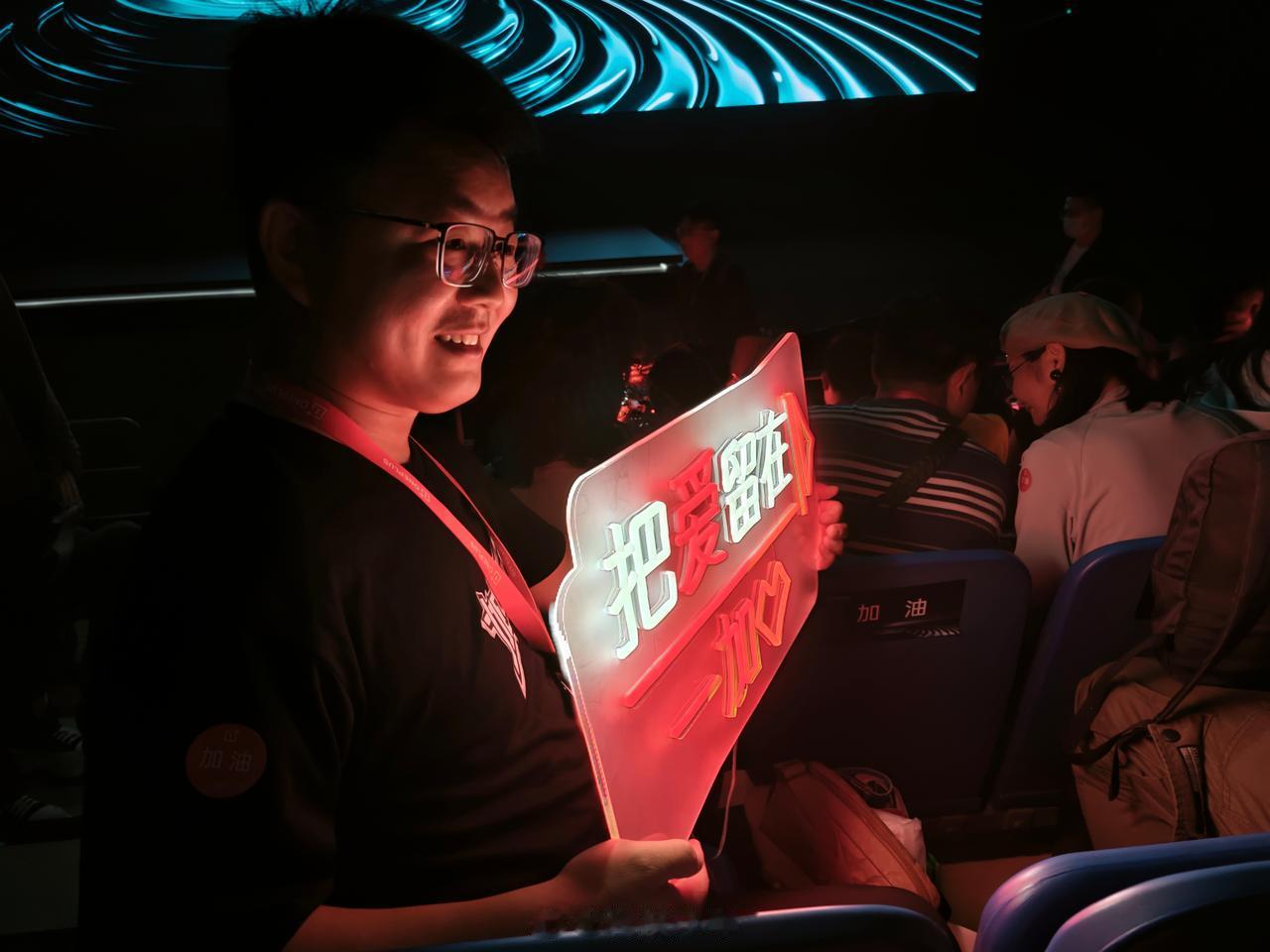 发布会现场，座位前面是一加手机的粉丝团，看到他们激动，热情的欢呼，拿灯牌，拍照，