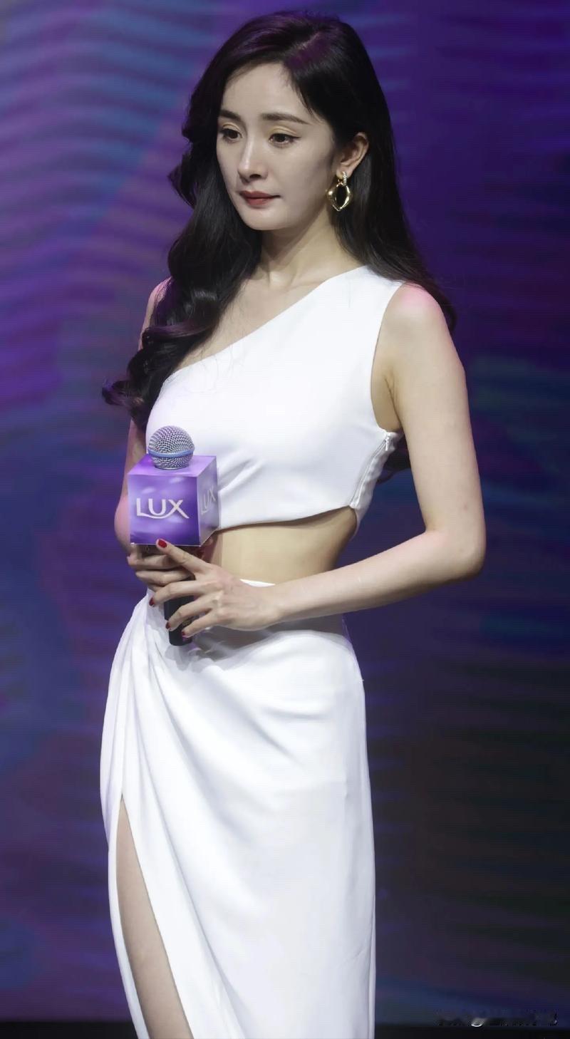 杨幂‌身着‌白色露腰高叉长裙‌，纤细的腰肢让人心旷神怡！