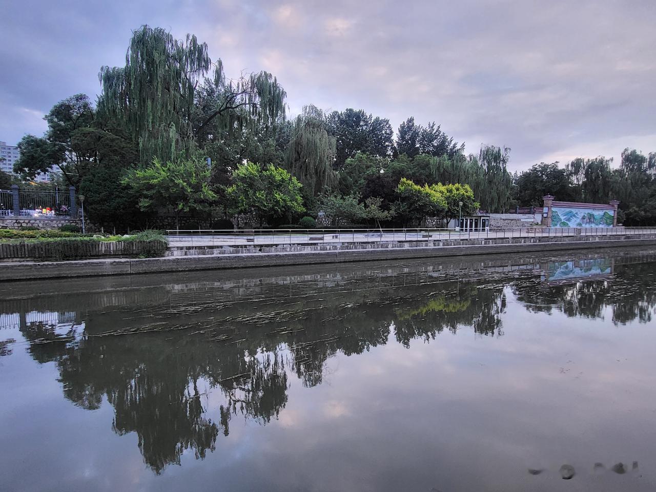 河道公园的美景宛如一幅流动的画卷。河水澄澈透明，波光潋滟，在阳光的照耀下仿若洒下