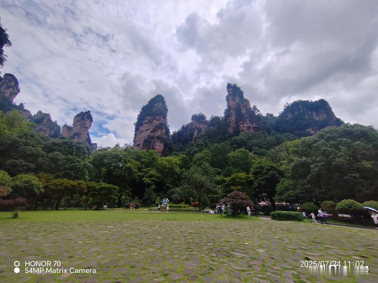 山雨刚歇，张家界的石峰像是浸在了清冽的泉里。抬头看天，云层还未完全散去，空气里的