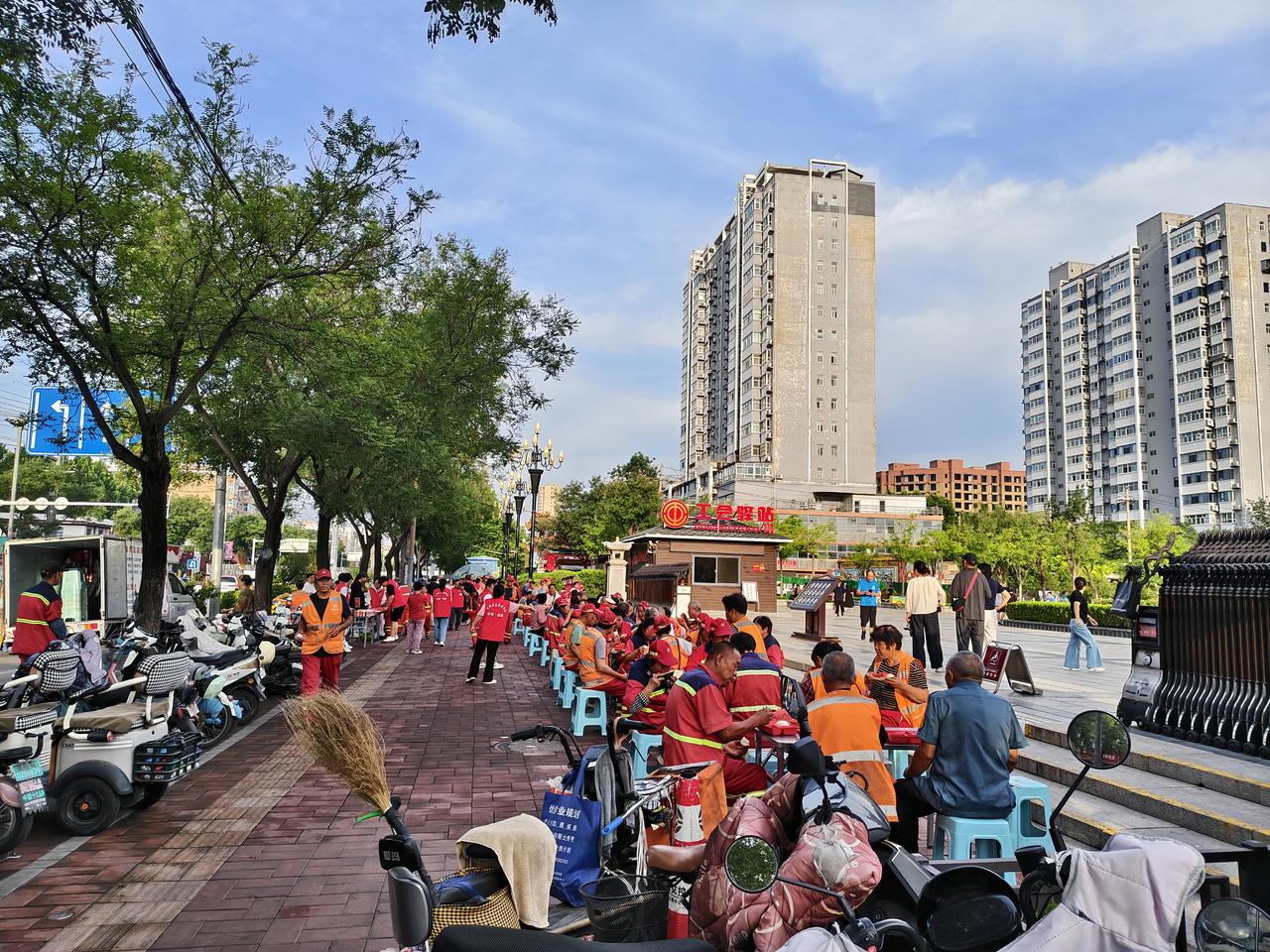 清晨，6点38，运城西花园门口清洁工师傅们已经围坐在桌子旁，享用早餐啦！

志愿