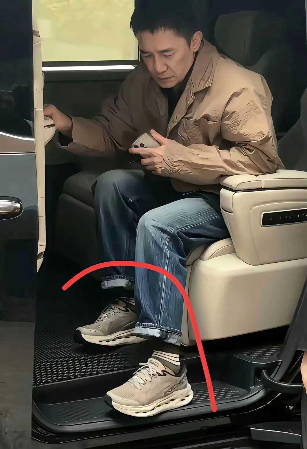 画面中坐在车内的梁朝伟胖瘦合度，衣着休闲，浓眉立鼻，上衣袖口处皱皱巴巴，脚上穿的