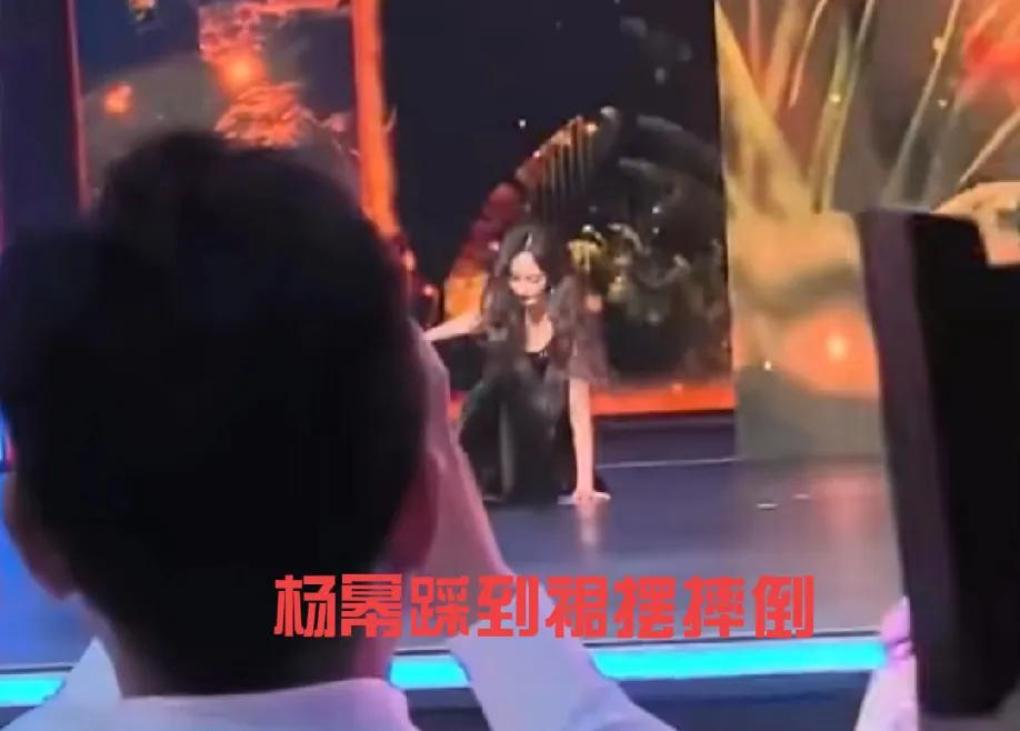 杨幂上台不小心踩到裙子摔倒了，然后迅速站起来，面带微笑继续往前走，在自我介绍的时