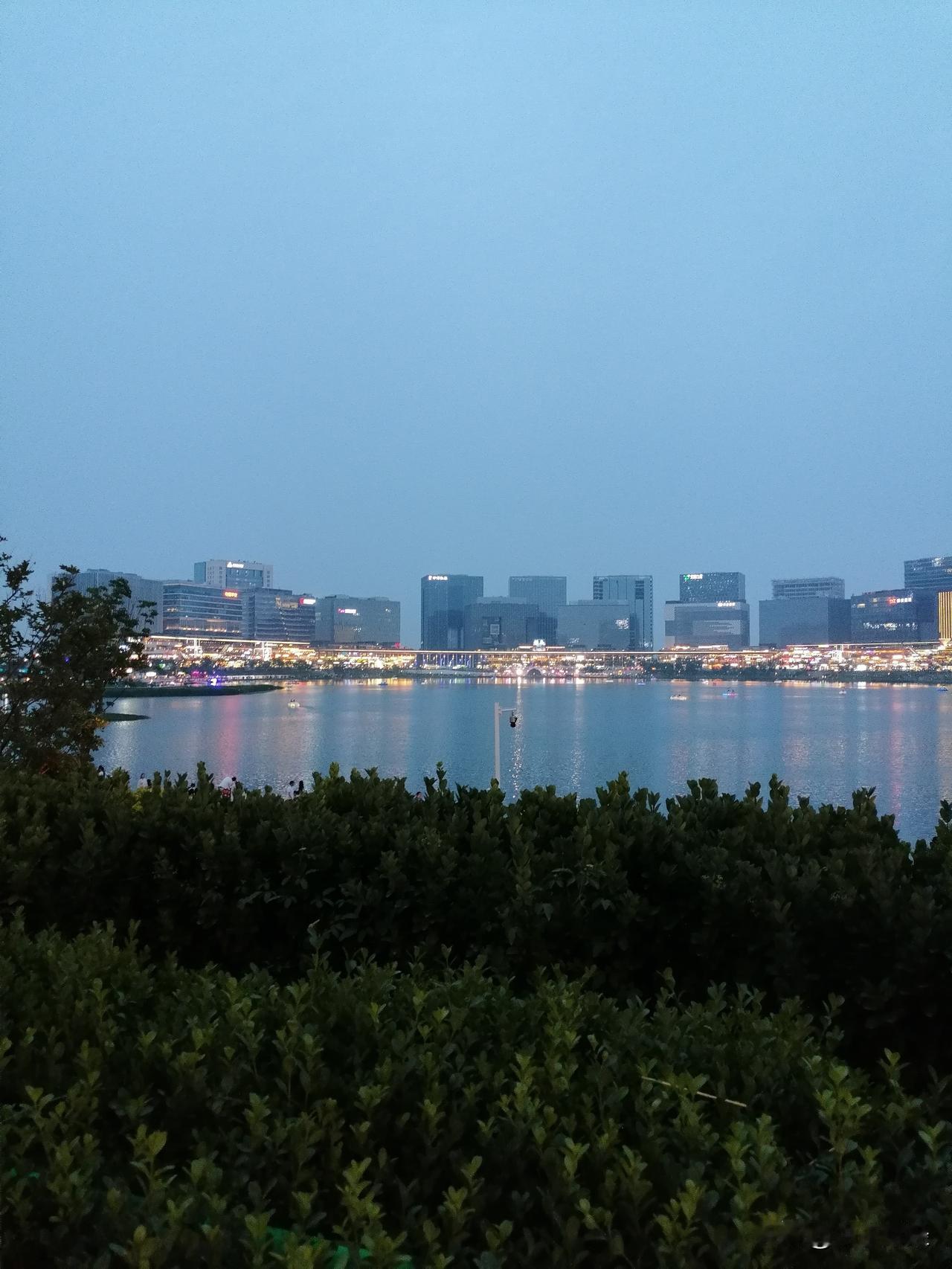 晒晒我的摄影作品傍晚时分，华灯初上！透过静静的湖面，看着远方的现代化建筑，你是否