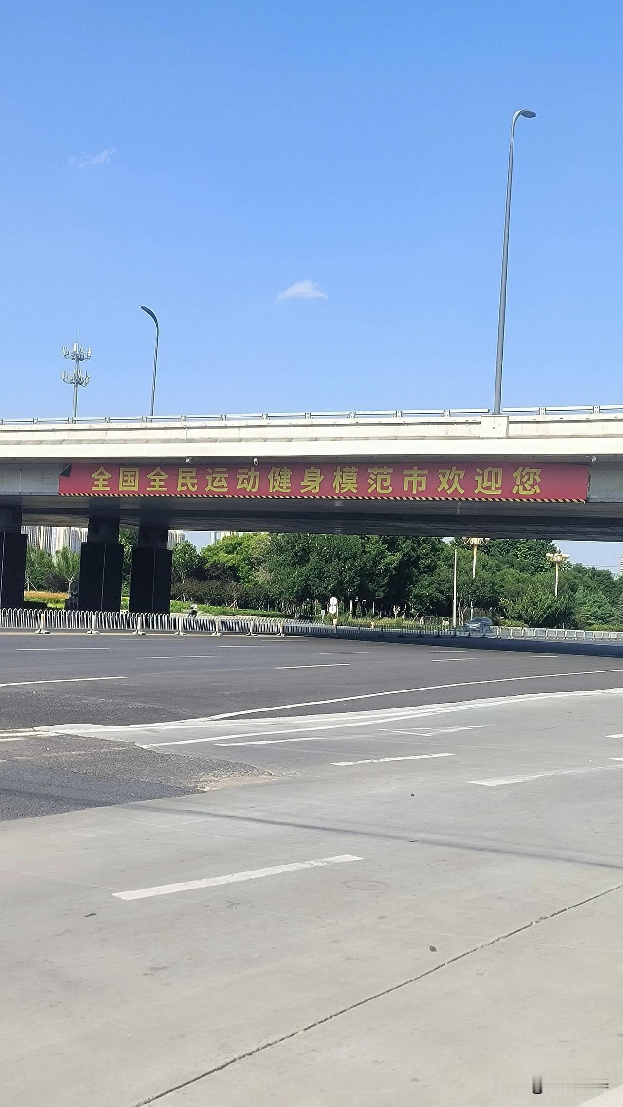 东望保定东二环快速路桥下七一路口，
宽阔的路口，车水马龙
红色的标语，让人眼前一