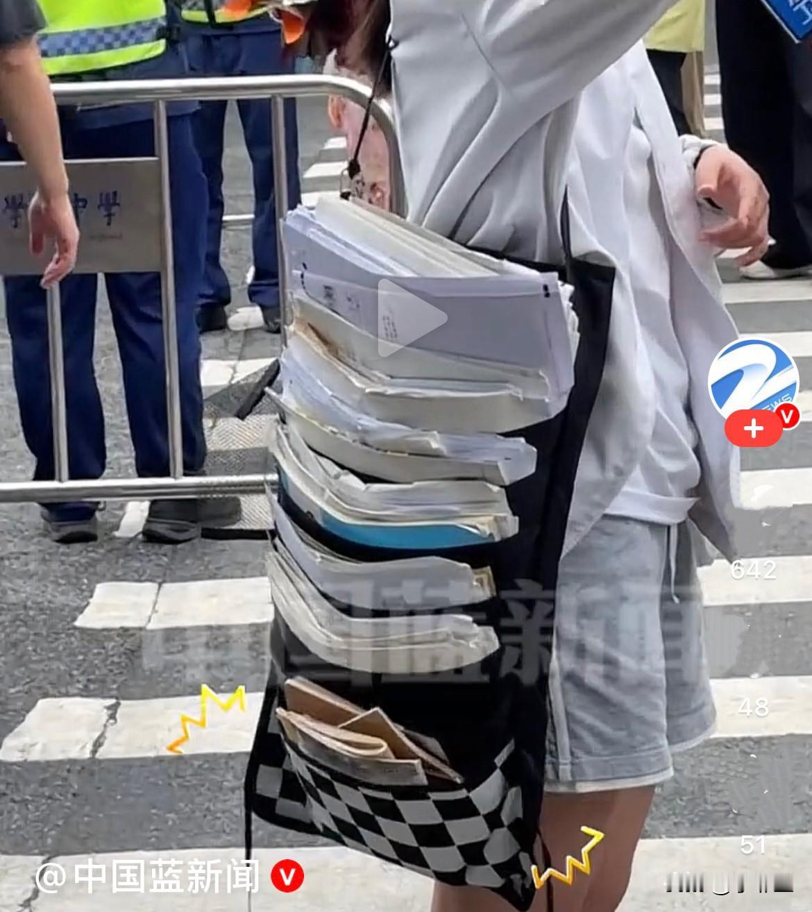6月9日浙江，高考结束了，一名女生把三年来刷过的所有卷子、资料一股脑全装书包里背