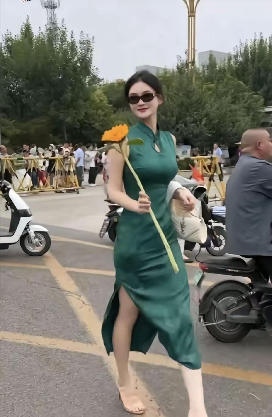 优雅漫步，绿裙与花相伴，都市中的自然之美。
