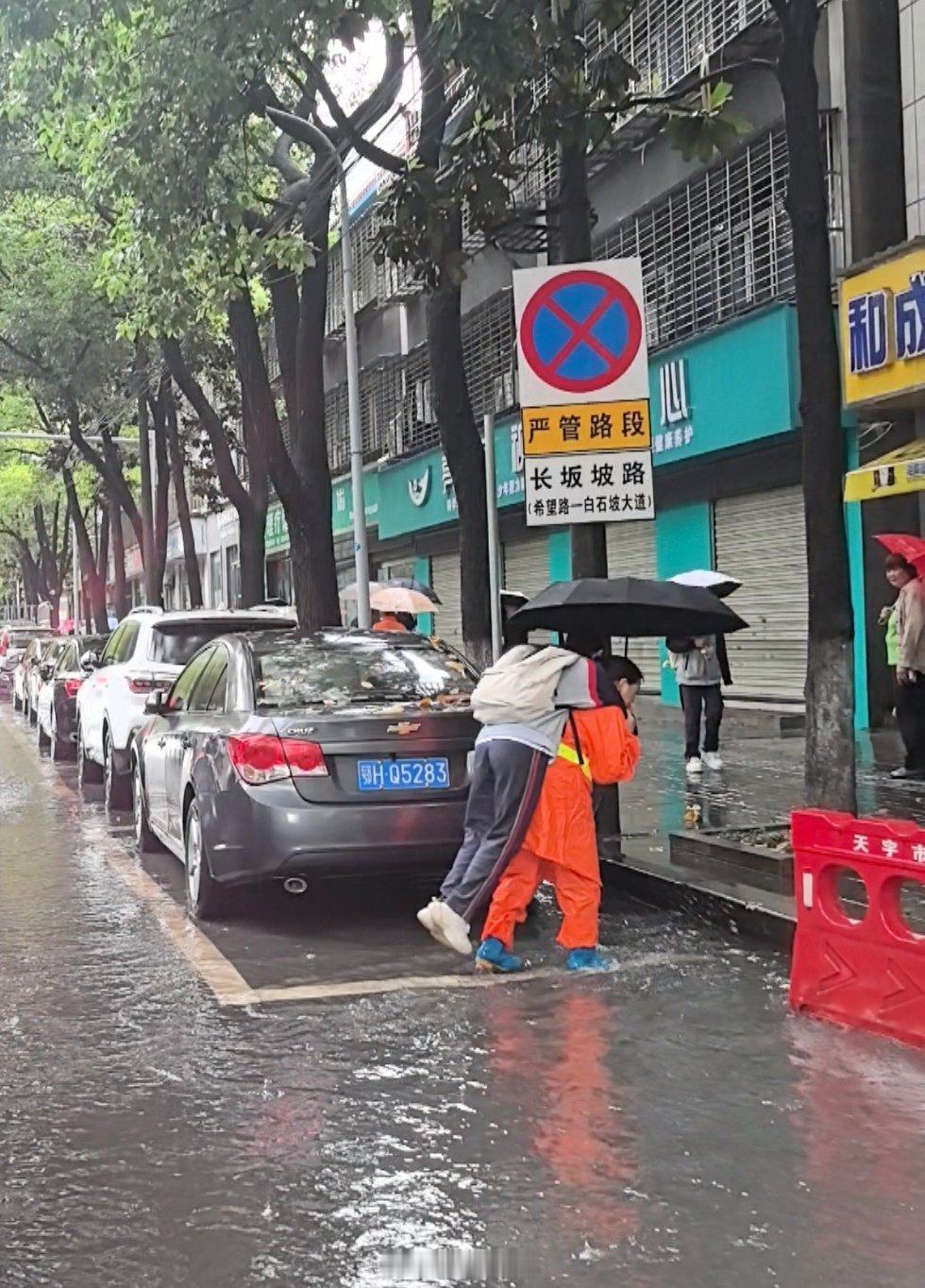 背学生蹚水女环卫获500元奖励暴雨路面积水，上学孩童寸步难行。湖北荆门环卫阿姨王