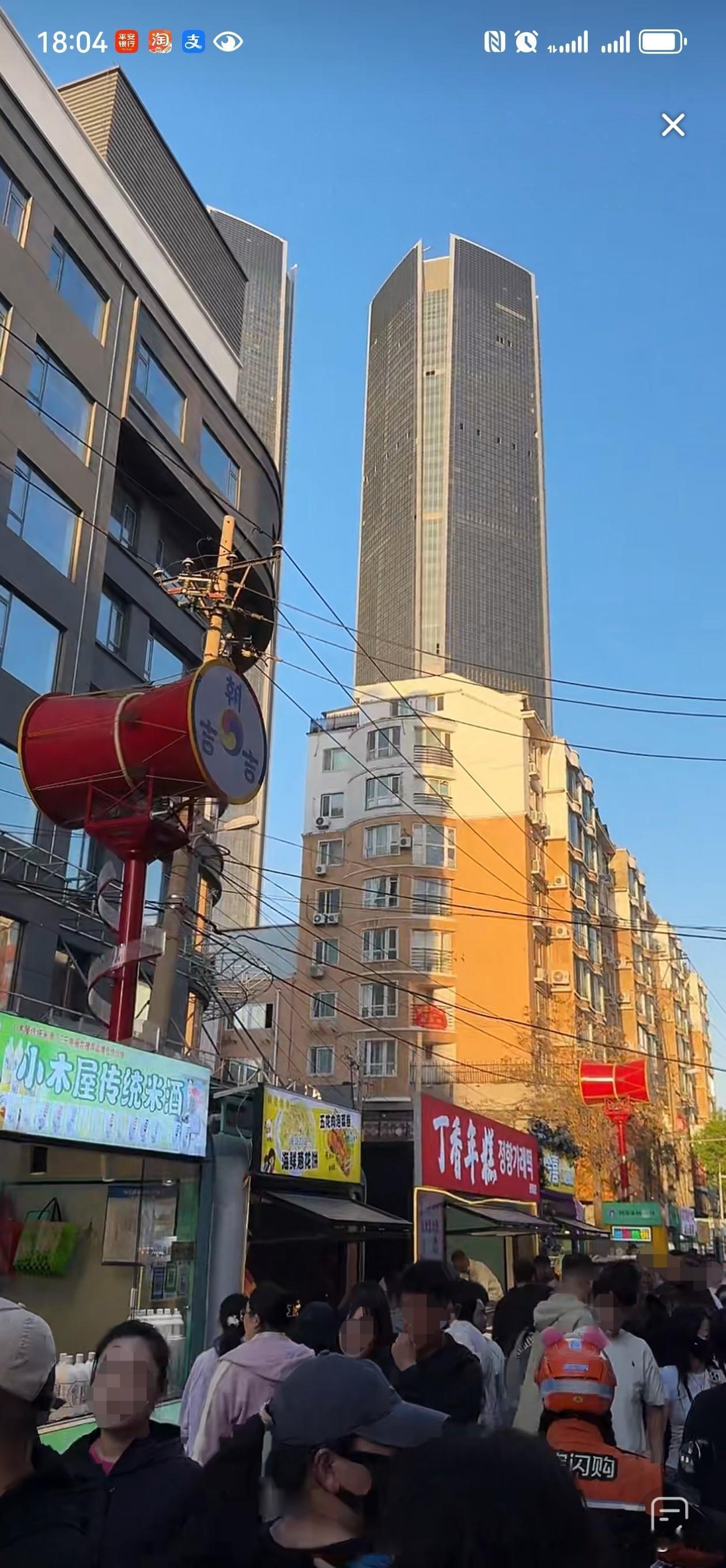 沈阳西塔的一条带感的小巷里，人潮涌动，夕阳的金黄撒在远处两栋330米的”沈阳世界