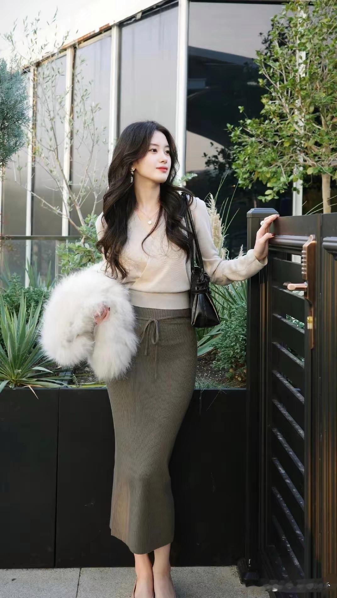 米色毛衣配灰绿色半裙，再手拿毛绒包，这穿搭简直优雅气质拉满！
选毛衣，版型比款式