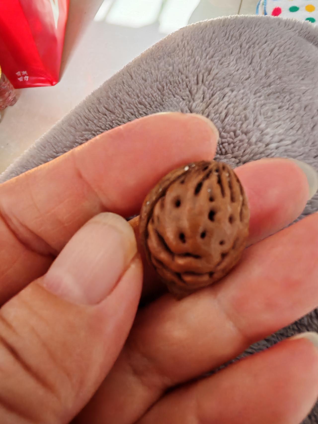 这枚桃核很萌的，像头牛的脸。
眼睛、鼻子、嘴巴都清晰可辨。
请仔细看一看，是不是