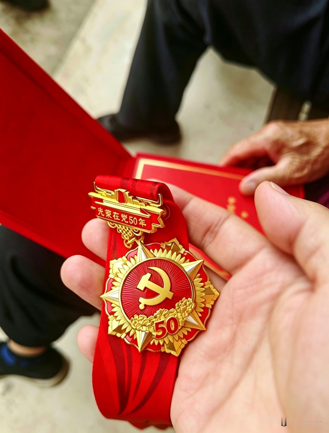 这是我们村首枚50年党龄纪念章。
老人当过五年兵，回乡守土半生，手上全是岁月磨出