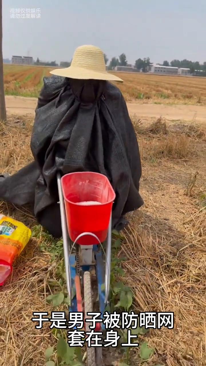 男子来到地里推肥料，由于媳妇担心天气太热晒住丈夫，于是男子被防晒网套在身上，这操