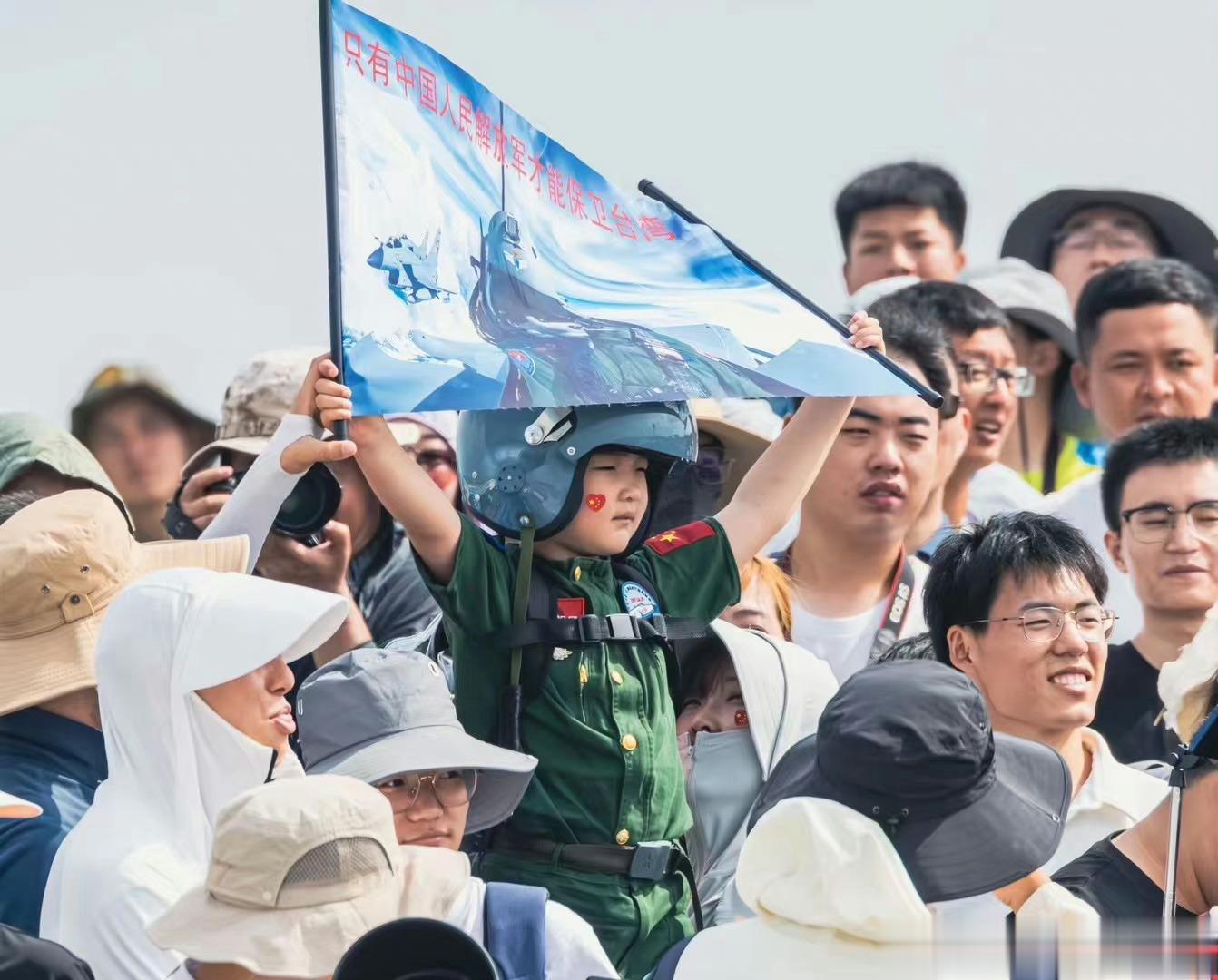 2023长春航空展现场十分喜人的一幕，一位3岁左右的小朋友身穿飞行员服、头戴飞行