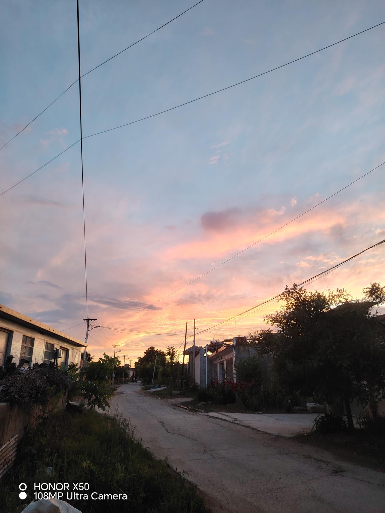 黄昏时分，宁静的乡村小路，电线杆与夕阳交相辉映。