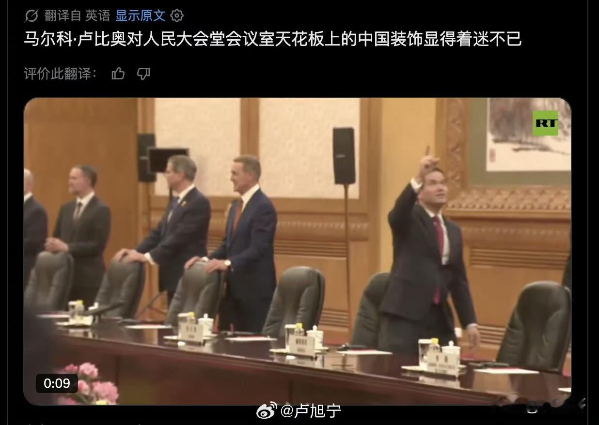 卢比奥对人民大会堂会议厅顶上的装饰产生了浓厚兴趣，还没落座就开始比比划划，并竖起
