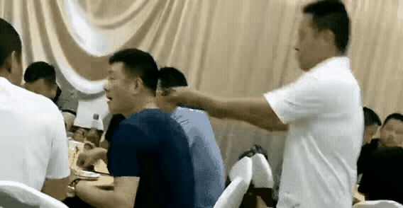 酒席上，一个男人正低头夹菜。身后突然窜出个人，二话不说，一根钢丝锁直接套他脖子上