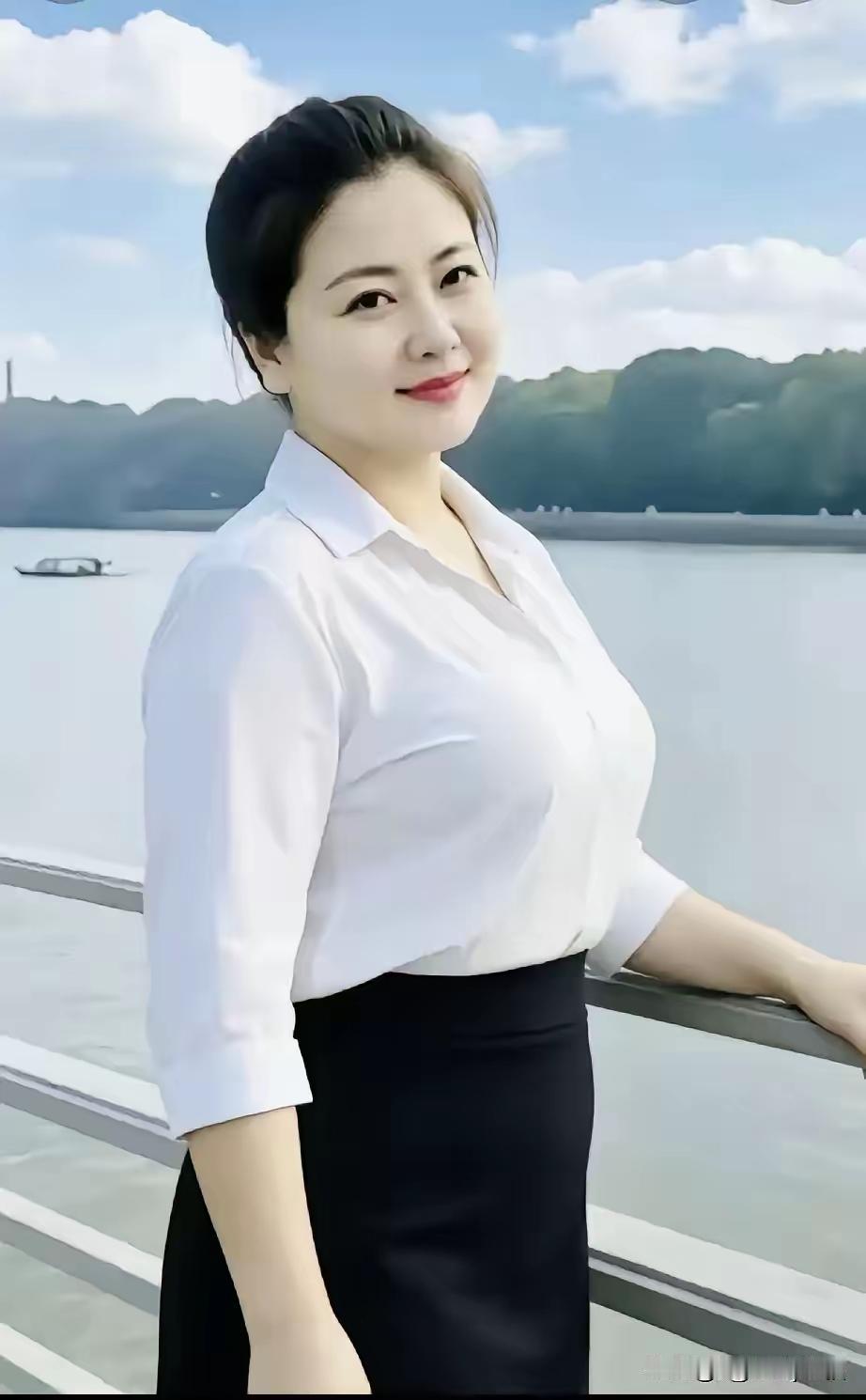 江畔丽姿
一江水碧映云天，
岸侧佳人倚栏前。
素袂简约神思畅，
笑靥柔嘉气质娴。