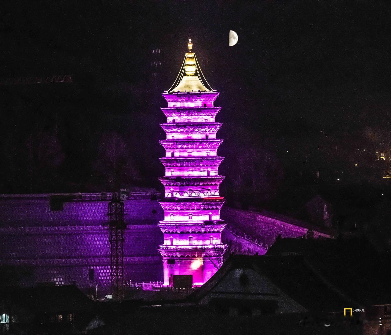 夜色如墨，五台山的古塔被紫霞般的灯光勾勒出层叠轮廓，金顶刺破夜幕，一弯残月悬于旁
