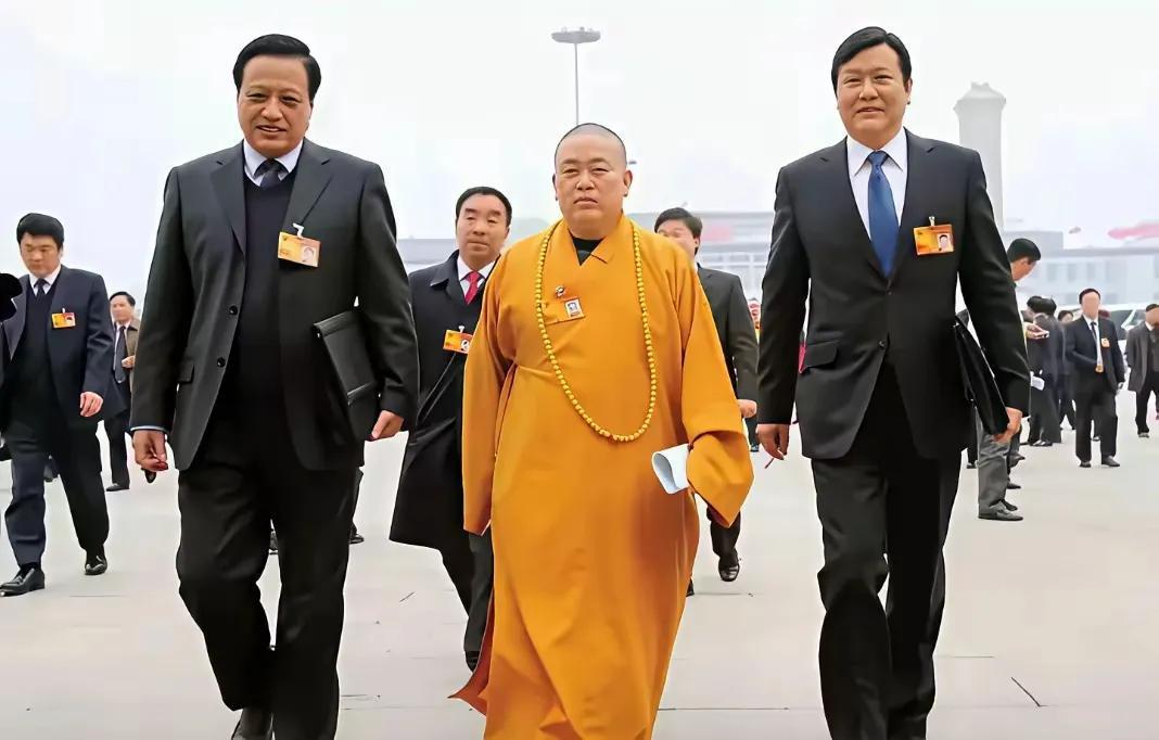 释永信的高光时刻！
释永信身穿明黄色袈裟，脖子上挂着硕大的佛珠，气宇轩昂地向前走