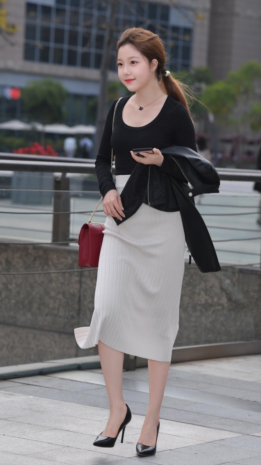 春日生活打卡季黑色U领针织衫+米白色条纹裙，脚踩一双黑高跟鞋，既得体又很有女人味