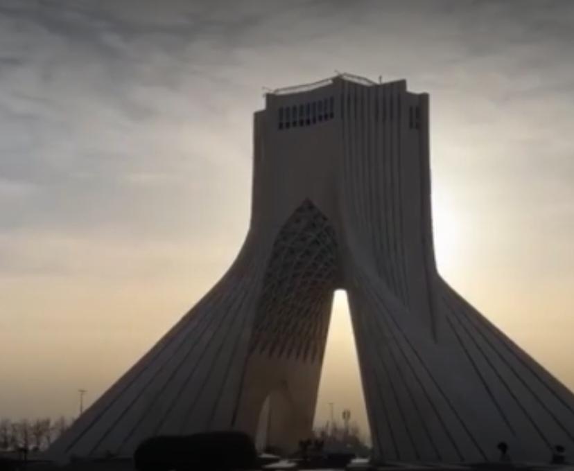 德黑兰的自由之塔与城市街景，勾勒出伊朗的日常图景，而导弹升空的轨迹与美国航母的部