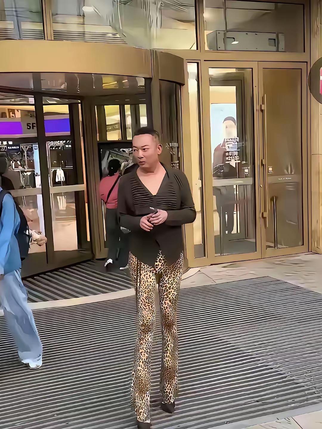明明是个男人，却身穿V领上衣，搭了条紧身的豹纹长裤，看着不男不女，给人的感觉十分