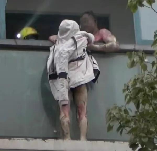 【生死考验】
在烈火中，丈夫死死拉住在阳台外的妻子，直到消防员救下妻子。
妻子大