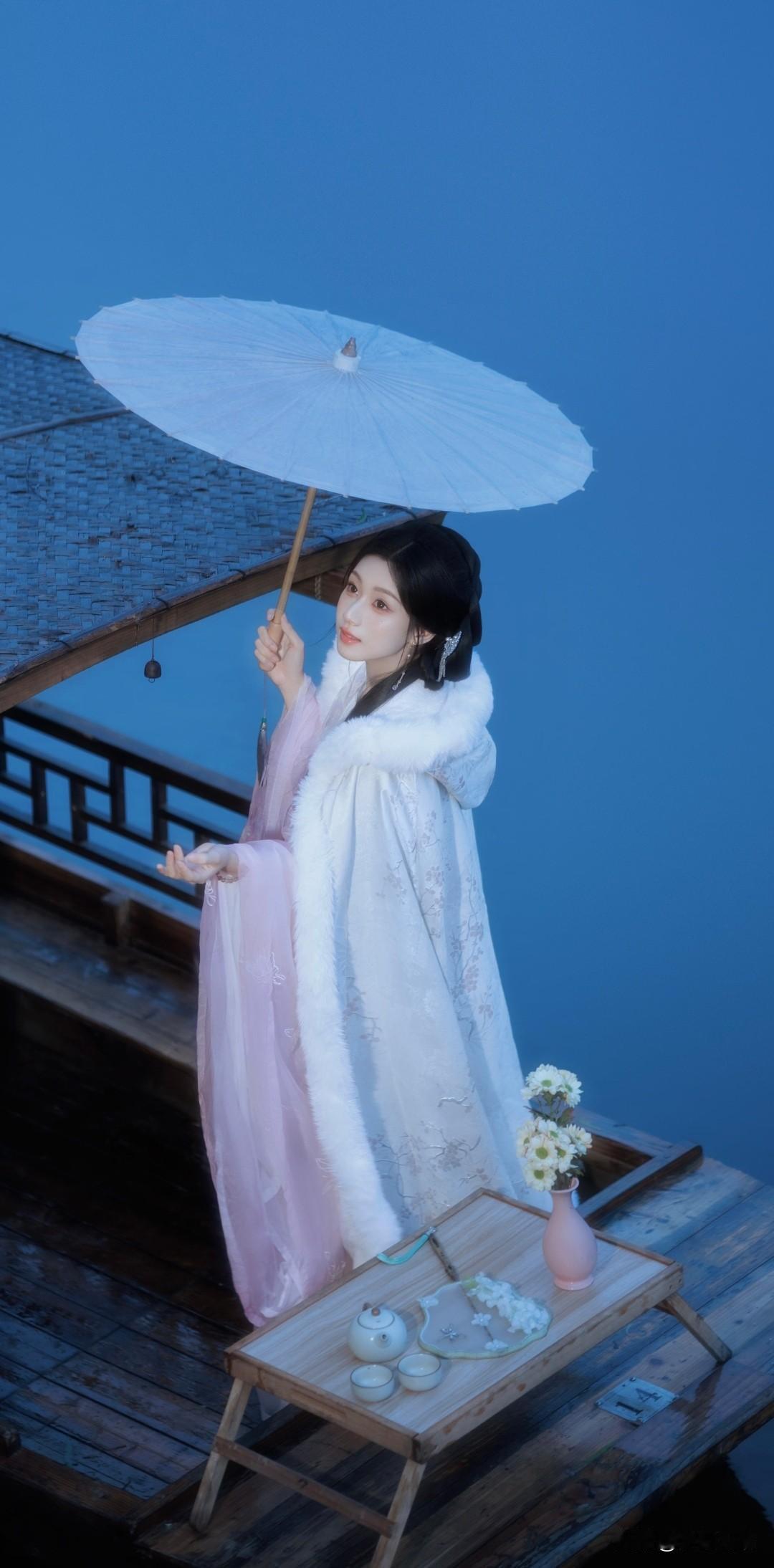 蒙蒙小雨中，古风少女撑伞在湖中的小船上，感受江南水乡的诗意与宁静。