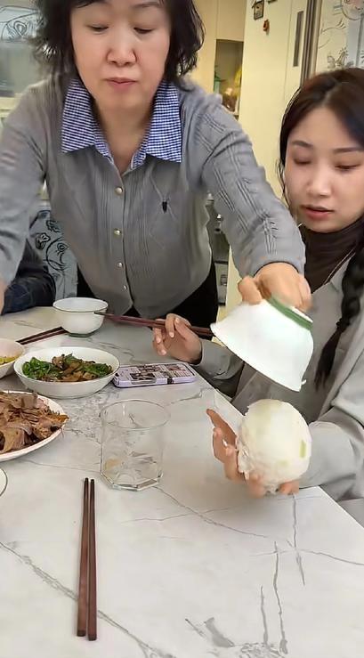 老婆边看着手机，边将饭碗递给老公，让老公快给自己盛点饭，丈母娘的反应，让女婿瞬间