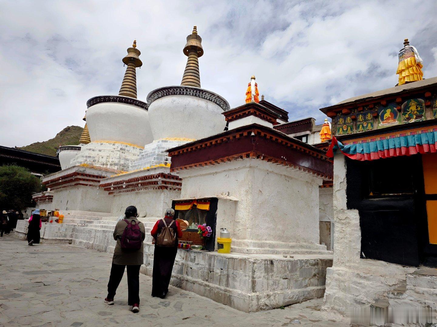 扎什伦布寺三座白塔、拉康，我就看一群人一圈圈地顺时针走，后面和侧面有转经筒。 