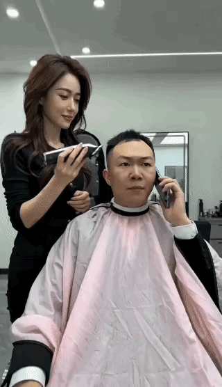 男士来理发店剪发，美女理发师接待了他，美女给他剪发时，他打电话与客户联系说“把中