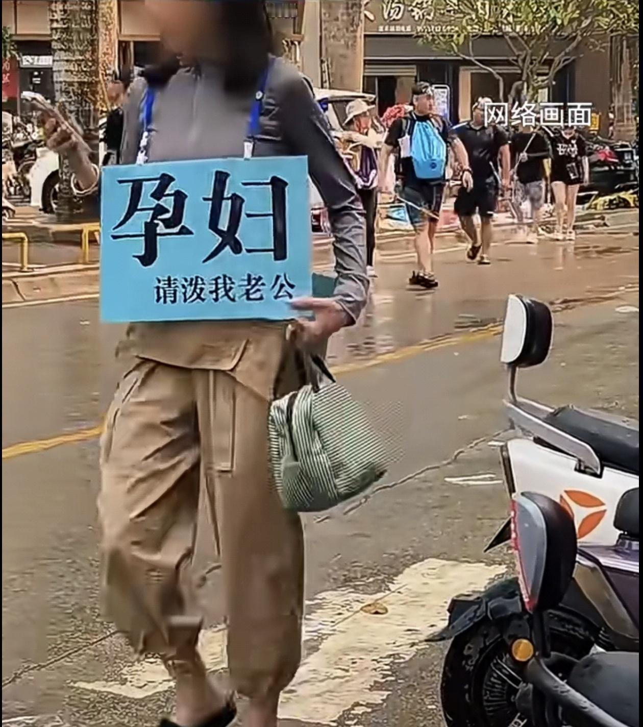 孕妈挂牌“请泼我老公”，西双版纳街头温柔默契的一幕。
 
一年一度的西双版纳泼水