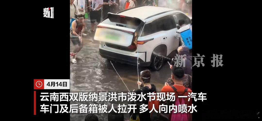 西双版纳泼水节多人向车内喷水 这个确实很奇怪，车辆行驶过程中后备箱门怎么会能打开