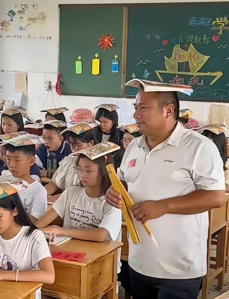 一位男老师头顶课本走进了教室，而进去以后才发现，全班所有学生都一样，全是头顶课本