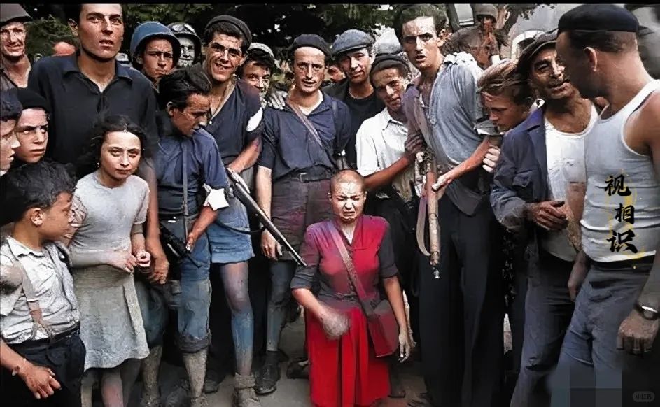 1945年，法国街头，一位被剃成光头的女子跪在地下，镜头中的她在痛哭流涕，周围站...