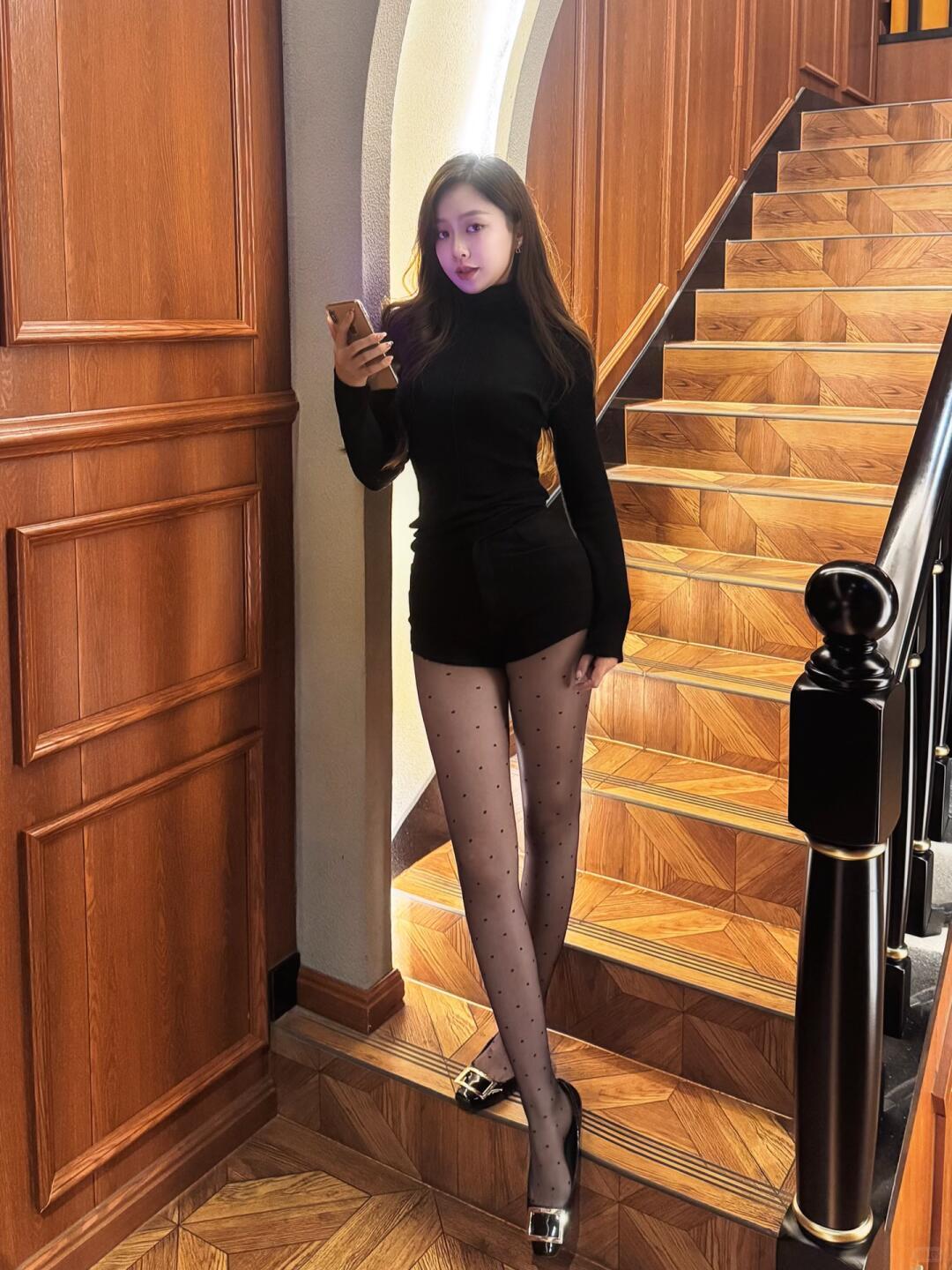 优雅黑衣少女，手机轻拍，楼梯间里的时尚瞬间。穿搭 性感 好身材性感女神 短裙搭配