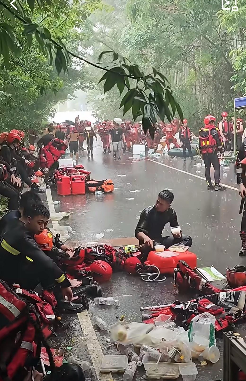 贵港救援人员席地而坐，饭菜和着雨水一同咽下，不知是米饭填饱了肚子，还是雨水装满了