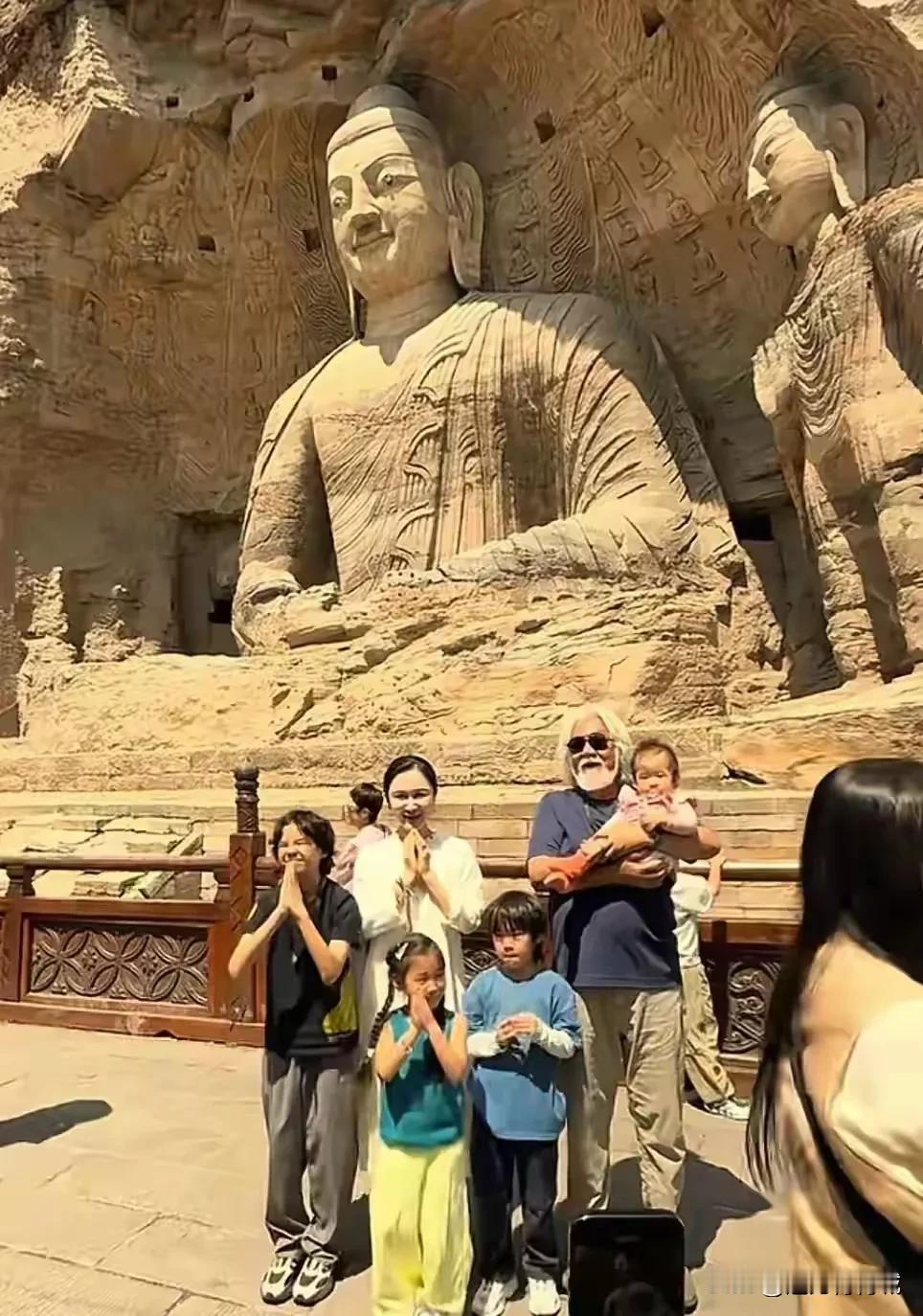 张纪中携妻子杜星霖及全家6口游云冈石窟，在大佛前面合影留念幸福感满满！张导和妻子