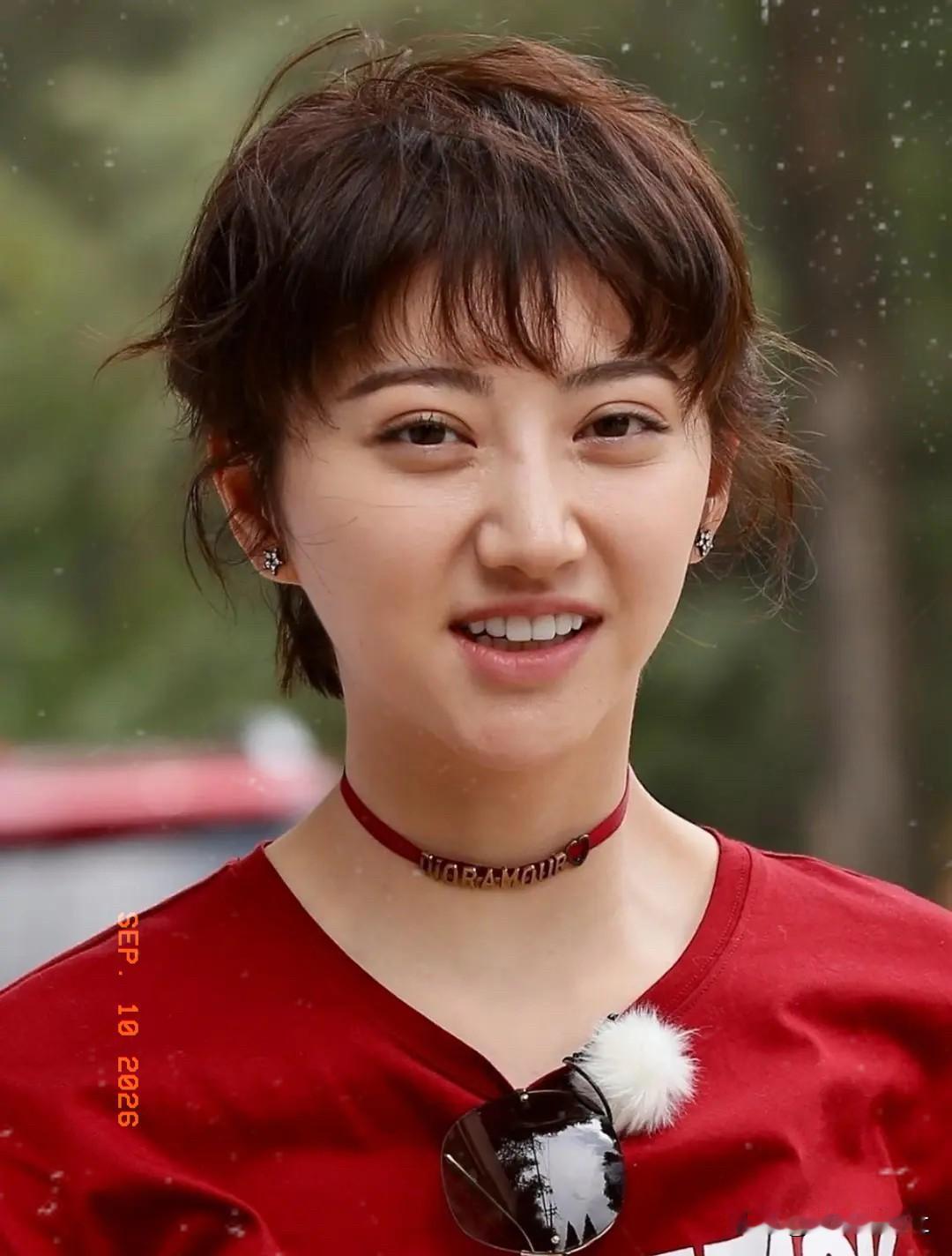 妆，也没有浓妆的加持，短发蓬松随性，一件简单的红色T恤，让她少了荧幕里的华丽与距