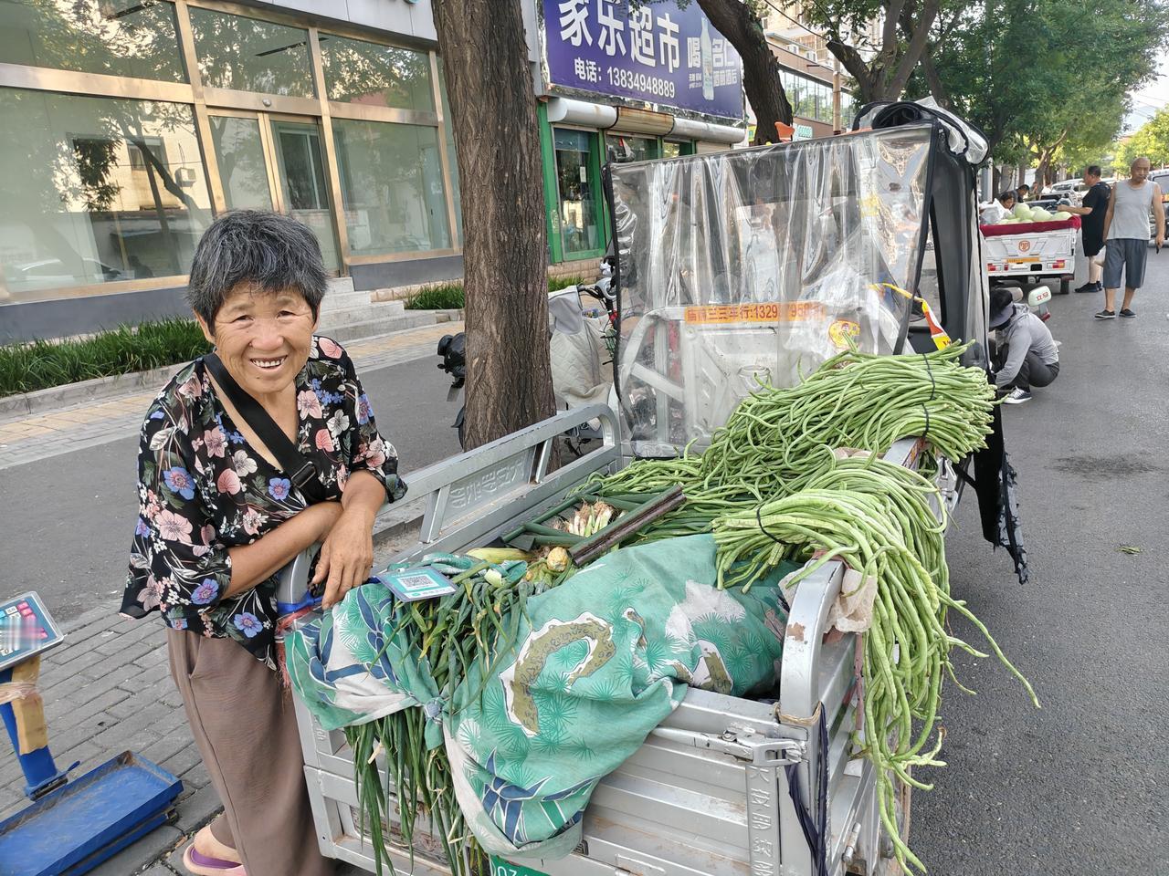 晨跑返回，在运城盐湖西街路边，看到一位大婶在卖菜，长豆角一元一斤，玉米5元一袋，