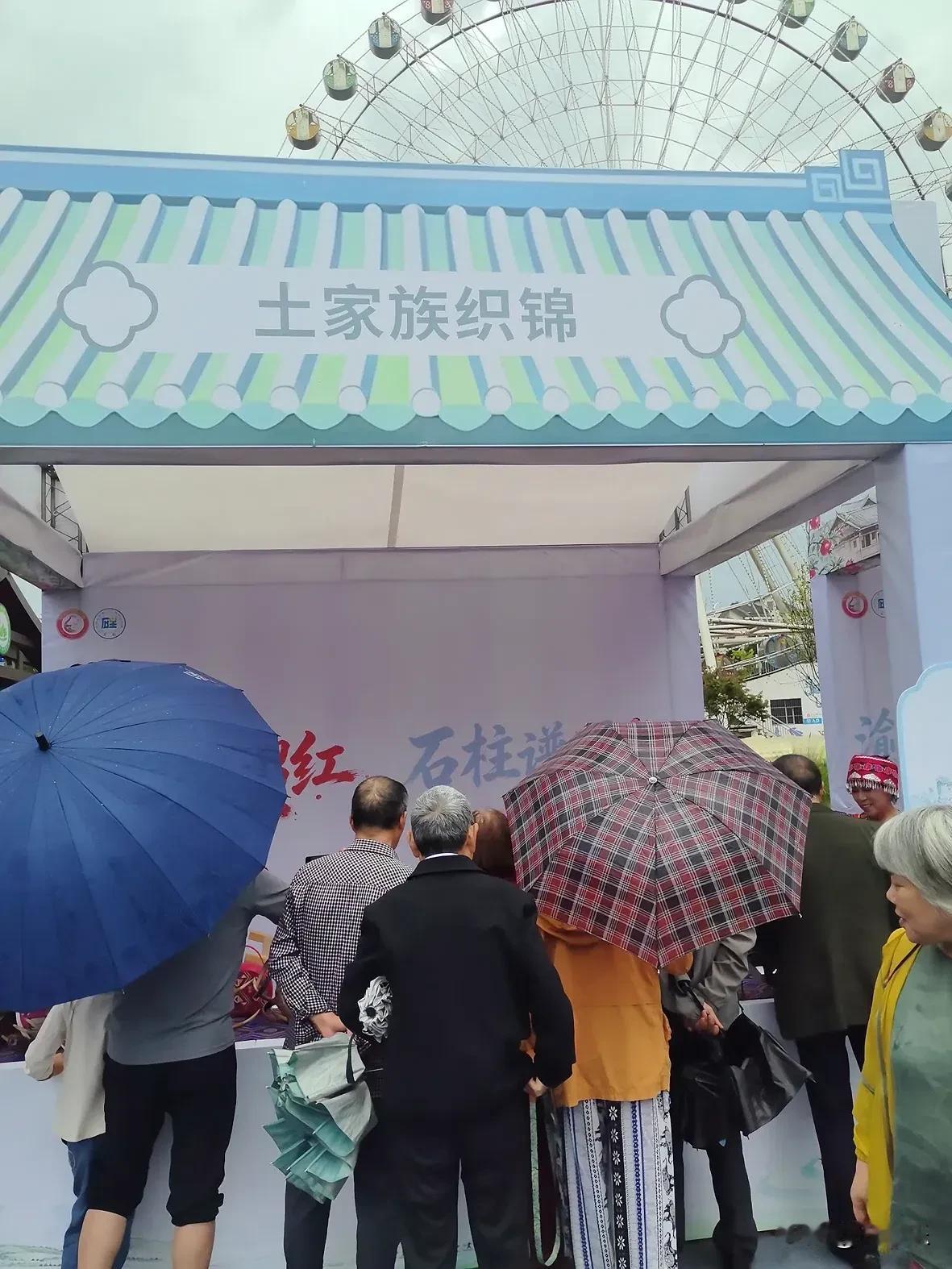 土家族织锦，把大山里的色彩织进日常的经纬里

雨中，大剧院广场上，一处挂着“土家