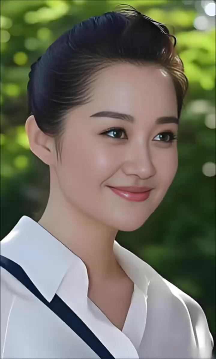 她容貌十分养眼，身姿饱满而匀称，举手投足大方且不失风度。一袭锦衣为她平添光彩，内