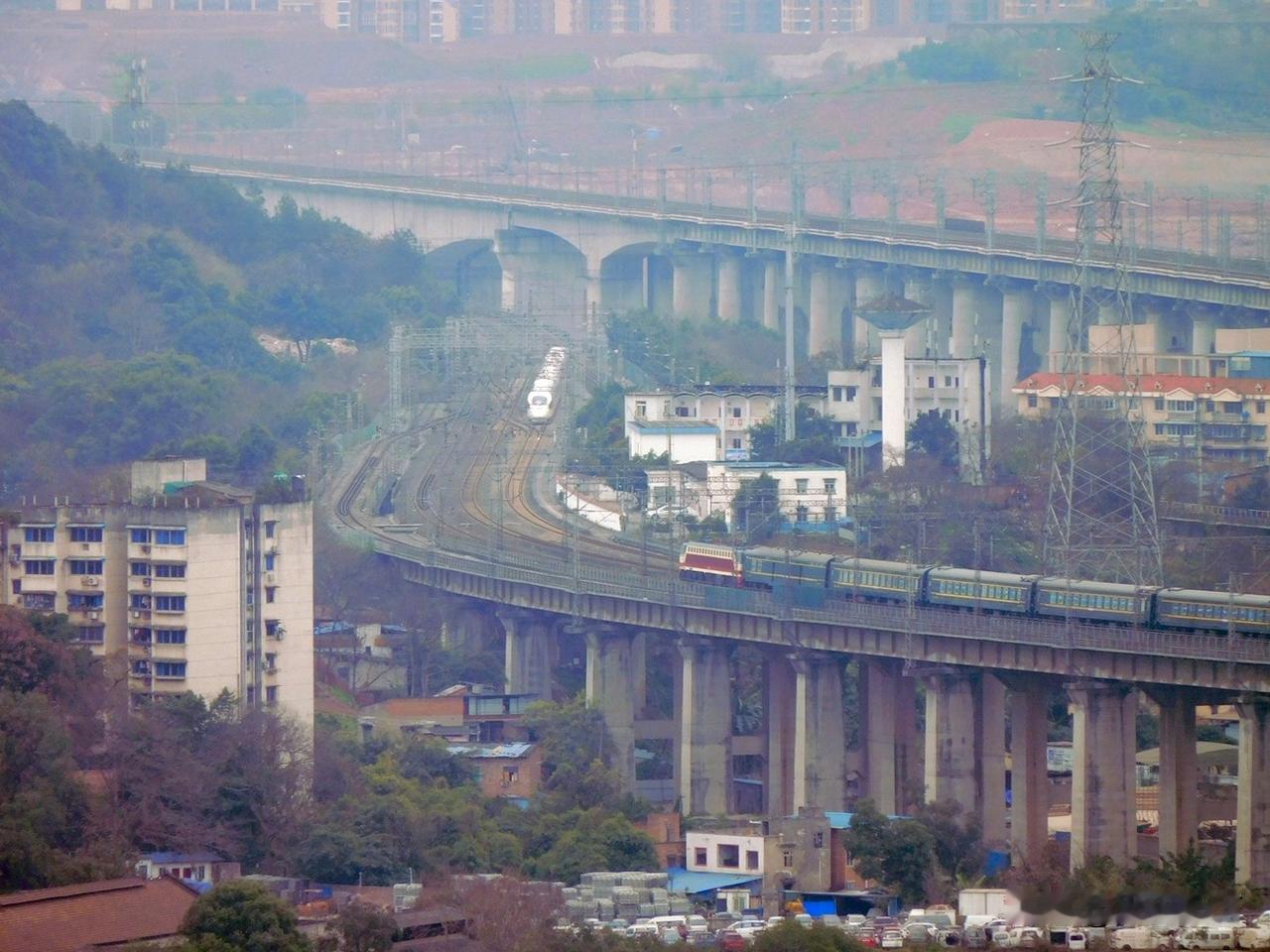 2019年，重庆铁路枢纽井口站，一列普速客车与动车组会车，远处更高的是新井口嘉陵