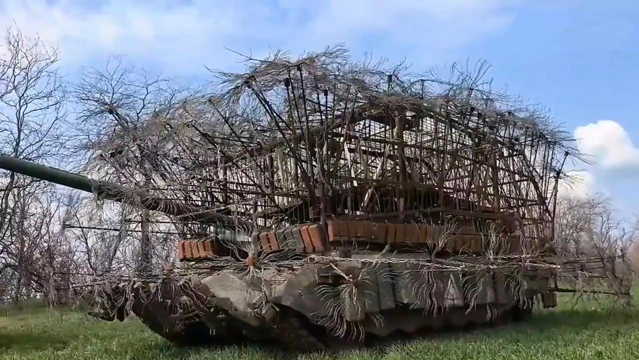 俄军T-90M主战坦克为了防无人机，加装了层层叠叠的防护措施，包括铁笼子、“刺猬