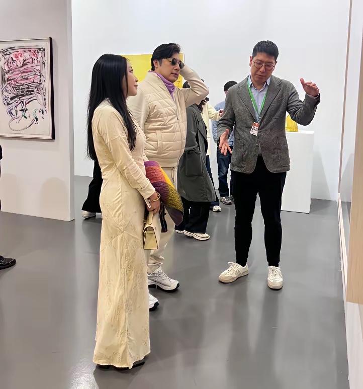 王岳伦这次被拍得有点措手不及，估计想捂镜头。
穿米白情侣装带长发姑娘看展，网友一