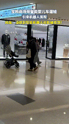 真的太卷了！北京宝妈抱娃逛商场，智能婴儿车全程跟走，直接把商场机器人都看呆了。