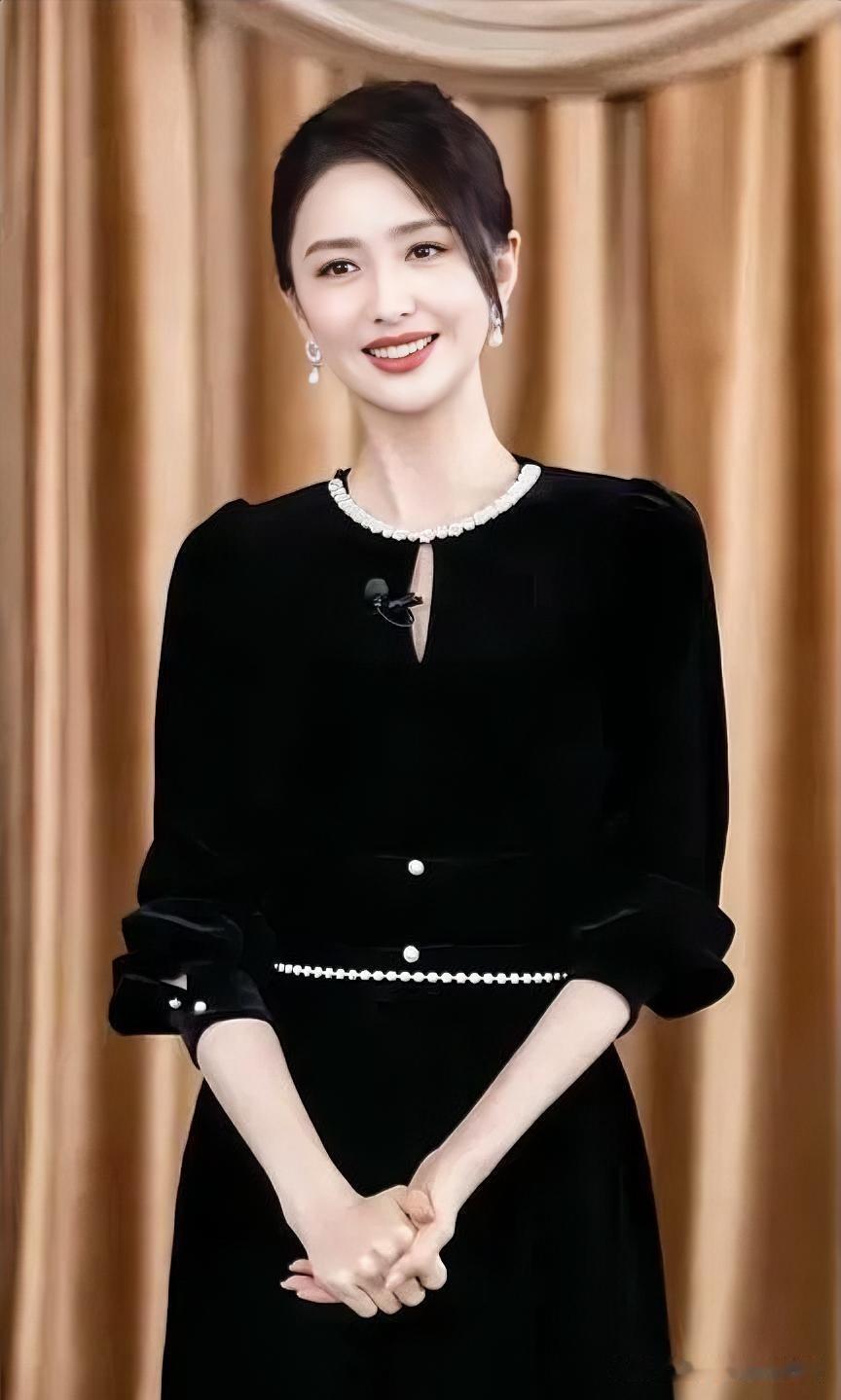 黑丝绒裙镶珍珠白，温婉笑容映暖帘，优雅与知性交织，尽显成熟女性的从容大气。