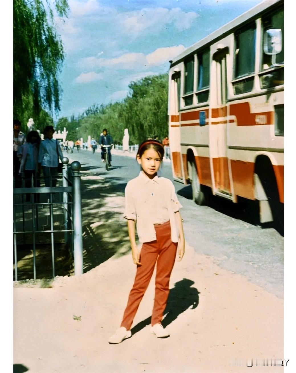 这是1988年，女孩在公路旁的留影。当年看似普通且笑容婉约的她，如今已是家喻户晓