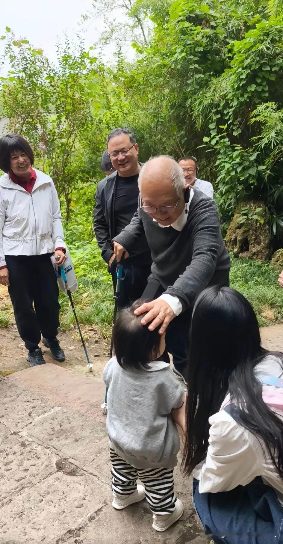 这是世界著名数学家丘成桐先生在北京郊区散步时，抚摸小女孩头部的温馨情景。
最近，